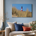 [ai-modified;e:living-room] Wandbild Leuchtturm durch Dünengras in einer Wohnsituation